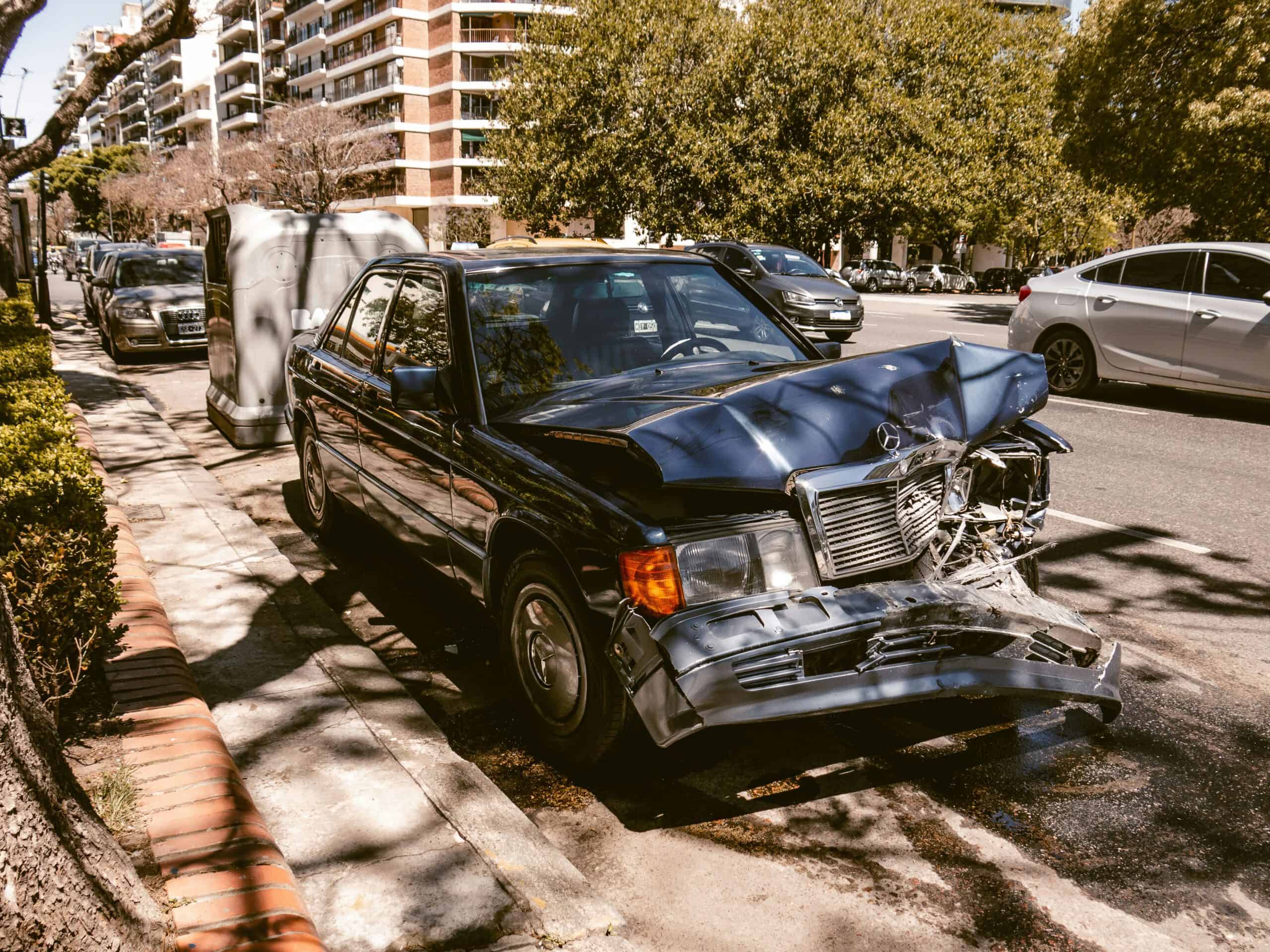 image of a wrecked mercedes on the side of the road for insurance claim